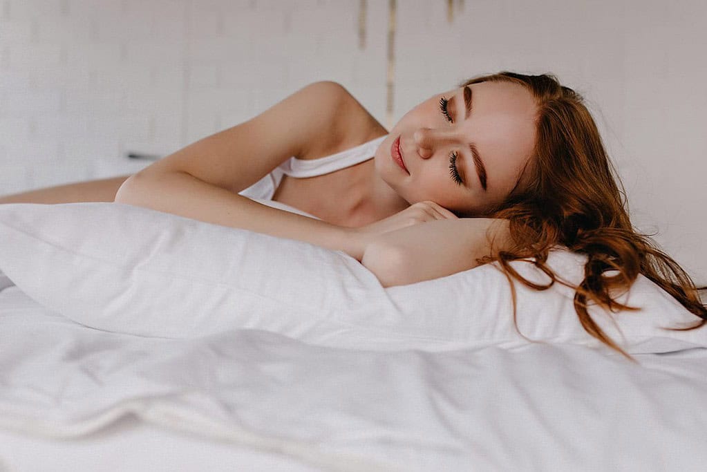 woman sleeping on a white pillow