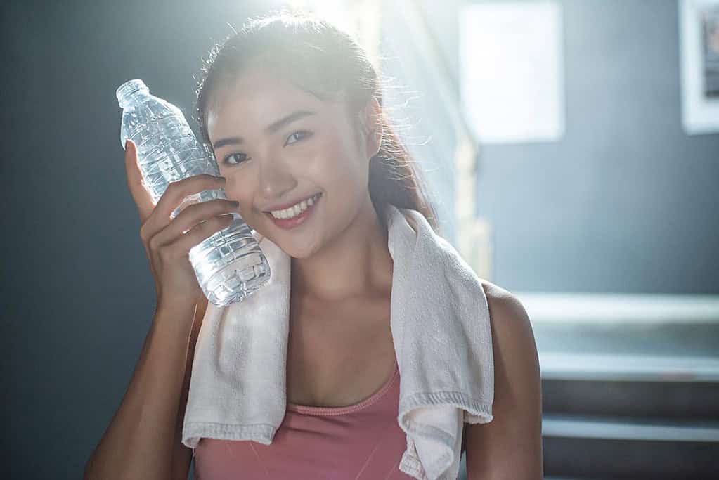 women drinking bottled water