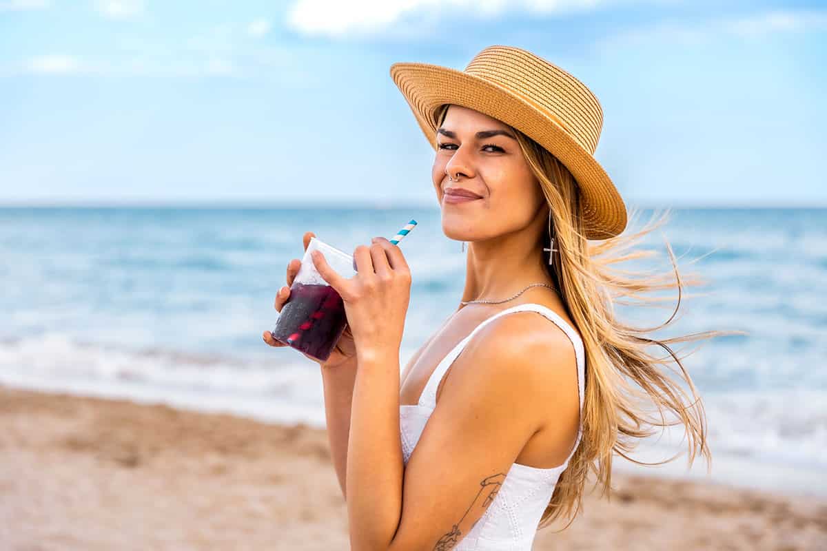 tourist-enjoying-refreshing-drink-sunny-beach